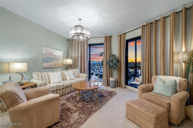 carpeted living room with an inviting chandelier