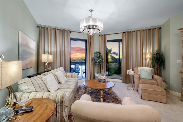 carpeted living room featuring a chandelier