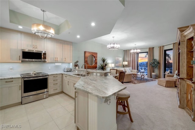 kitchen with decorative light fixtures, stainless steel appliances, and kitchen peninsula