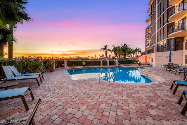 pool at dusk with a patio