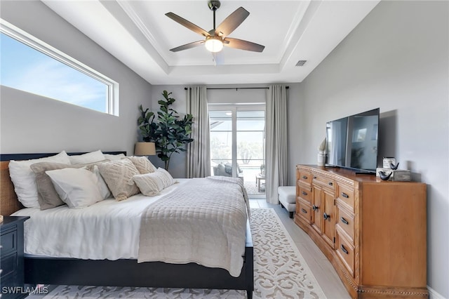 bedroom with multiple windows, a raised ceiling, access to outside, and ceiling fan