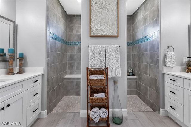 bathroom featuring tiled shower and vanity