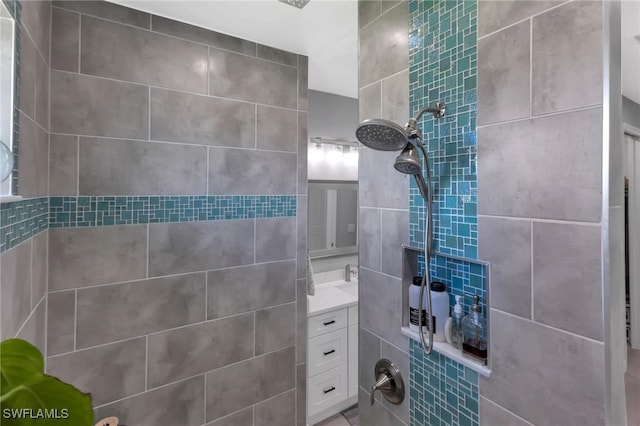 bathroom with vanity and a tile shower