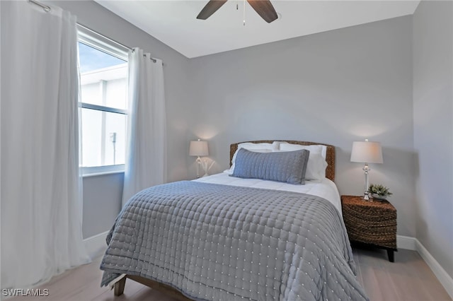 bedroom featuring multiple windows, light hardwood / wood-style flooring, and ceiling fan