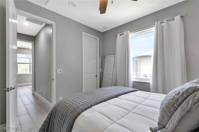 bedroom with ceiling fan and multiple windows