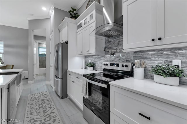 kitchen with white cabinetry, appliances with stainless steel finishes, backsplash, and wall chimney range hood