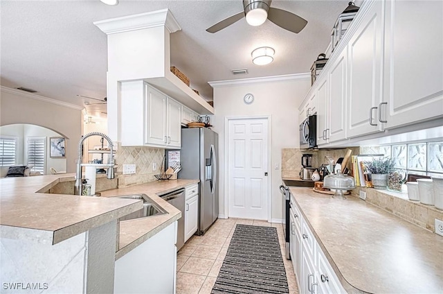 kitchen with appliances with stainless steel finishes, visible vents, crown molding, and a peninsula