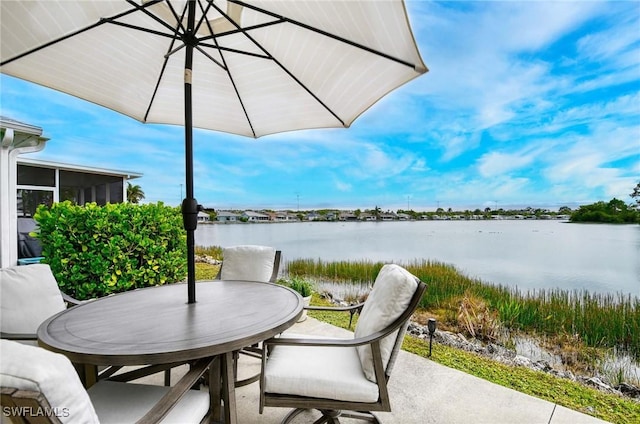 view of patio featuring a water view and outdoor dining area