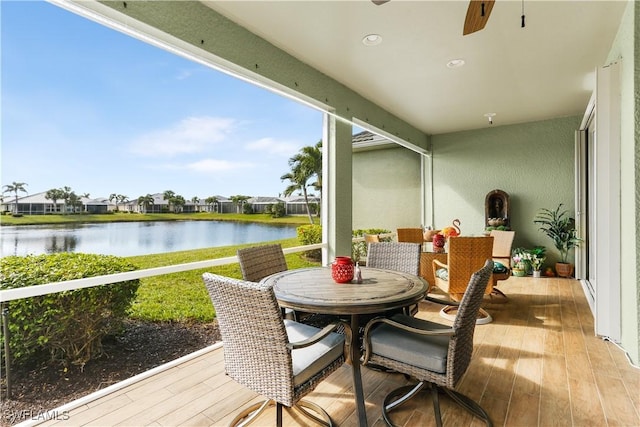 sunroom featuring a water view and ceiling fan