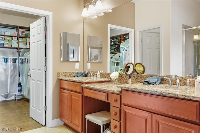 bathroom featuring vanity, wood-type flooring, an enclosed shower, and an inviting chandelier