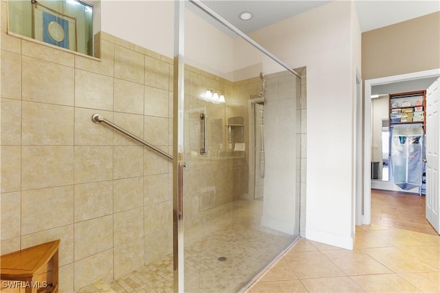 bathroom with tile patterned flooring and a tile shower