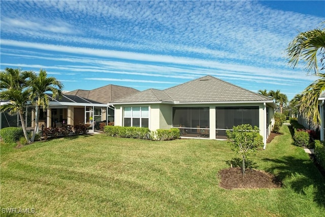 rear view of house featuring a lawn