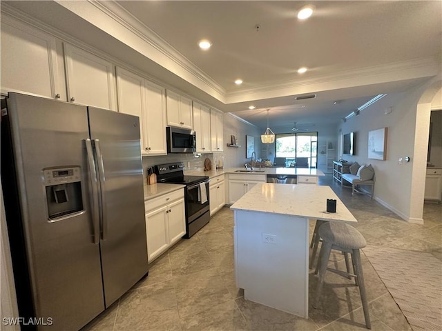 kitchen featuring a breakfast bar area, hanging light fixtures, appliances with stainless steel finishes, kitchen peninsula, and light stone countertops