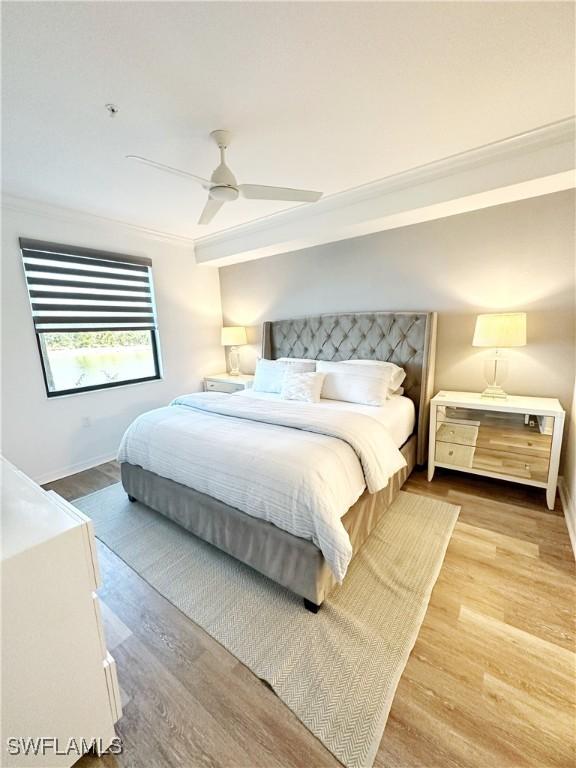 bedroom with ceiling fan, ornamental molding, and light hardwood / wood-style flooring