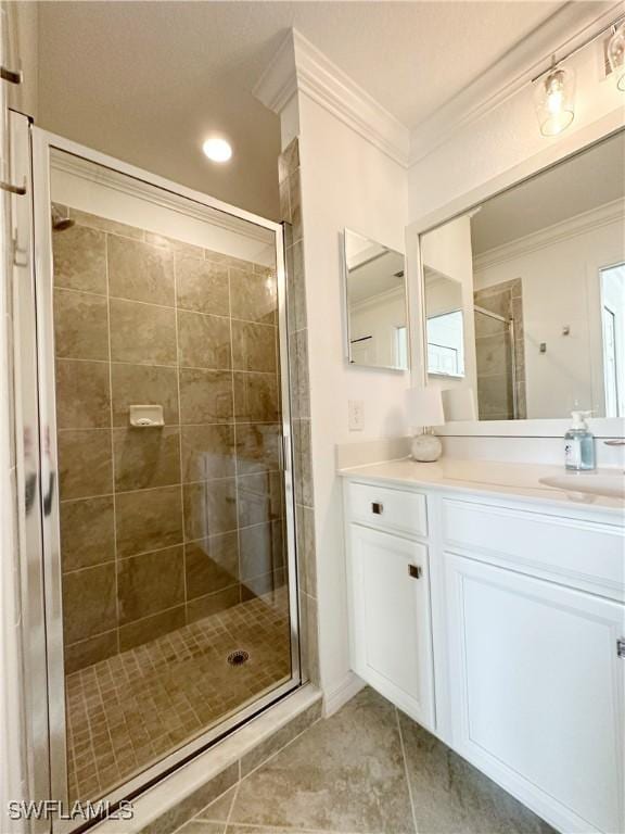 bathroom with a shower with door, vanity, tile patterned flooring, and crown molding