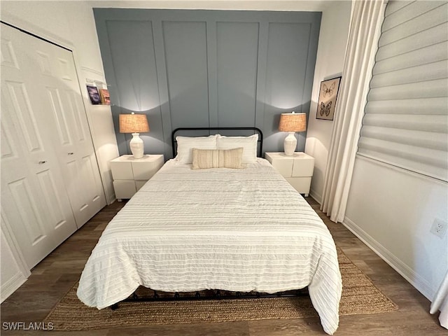 bedroom with dark hardwood / wood-style flooring and a closet