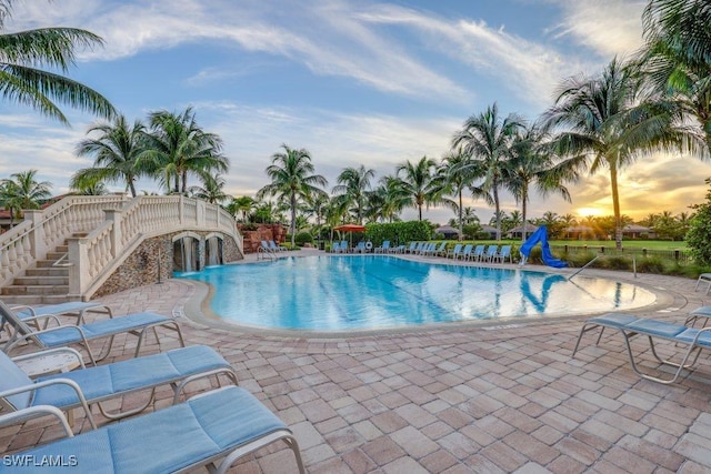 pool at dusk with a patio