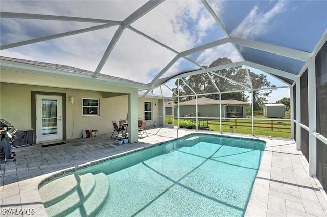 view of swimming pool with a lanai, a lawn, and a patio