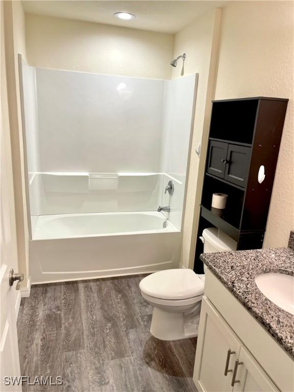 full bathroom featuring bathtub / shower combination, wood-type flooring, toilet, and vanity