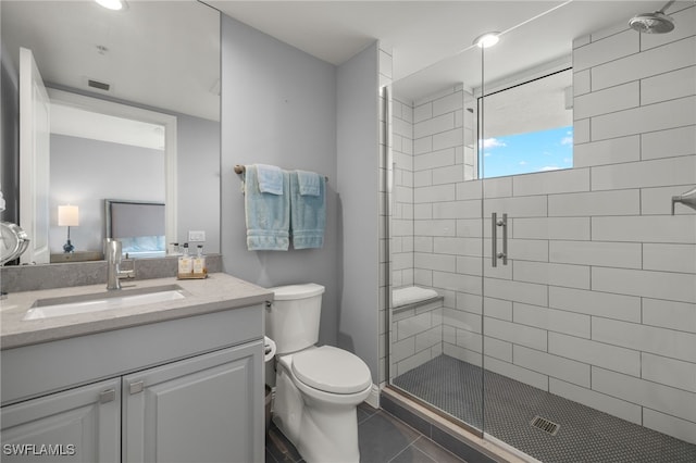 bathroom with tile patterned flooring, vanity, toilet, and an enclosed shower