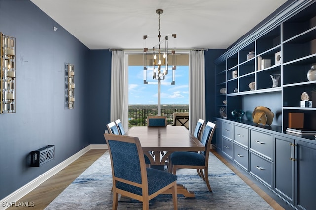 dining room with hardwood / wood-style floors and a notable chandelier