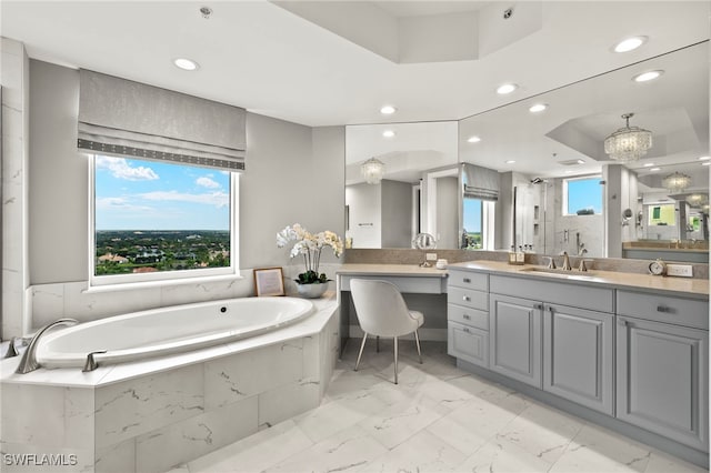 bathroom with vanity, a raised ceiling, and separate shower and tub