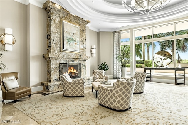 living area with a high end fireplace, a raised ceiling, and a chandelier