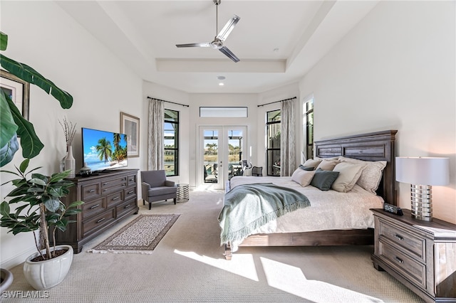 carpeted bedroom featuring french doors, ceiling fan, a raised ceiling, and access to outside