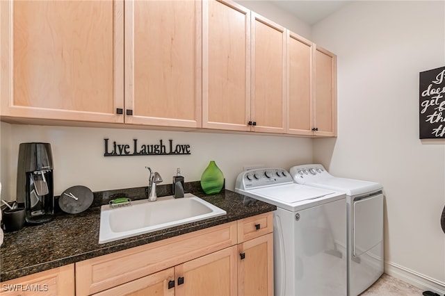 clothes washing area featuring cabinets, sink, and washing machine and clothes dryer