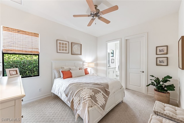 bedroom featuring ceiling fan, ensuite bath, and light carpet