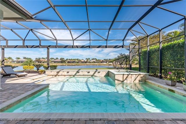 view of pool with an in ground hot tub, a water view, a patio area, and glass enclosure