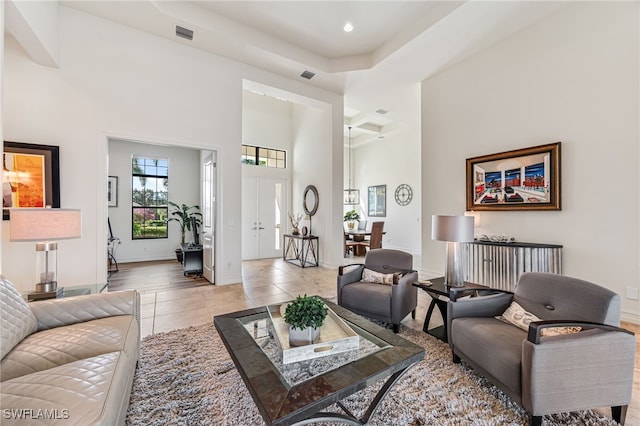 tiled living room featuring a high ceiling