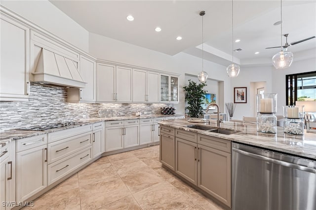 kitchen featuring sink, hanging light fixtures, custom range hood, stainless steel dishwasher, and black cooktop