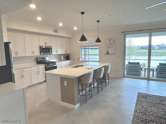 kitchen featuring appliances with stainless steel finishes, sink, and white cabinets