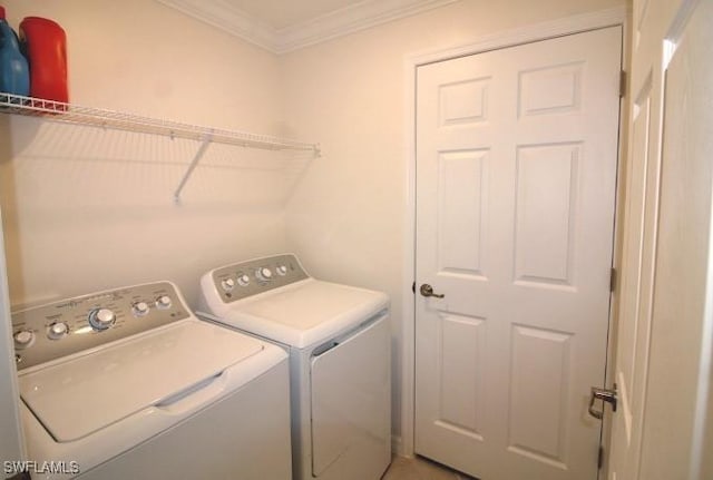 laundry room with crown molding and washer and clothes dryer