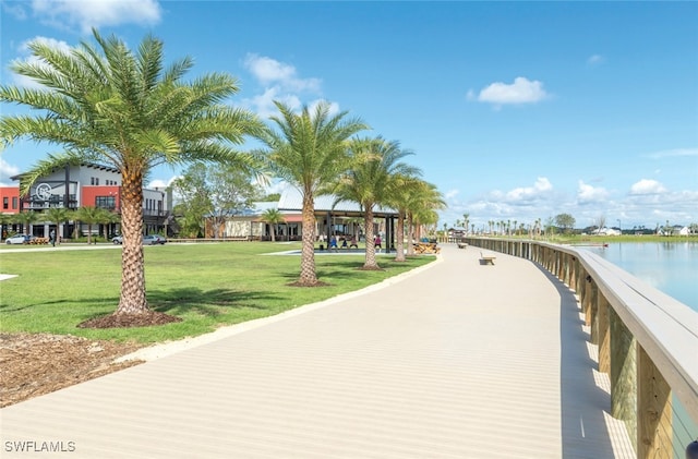 surrounding community featuring a water view and a lawn