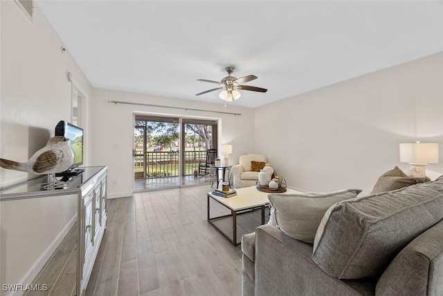 living room featuring light hardwood / wood-style floors and ceiling fan