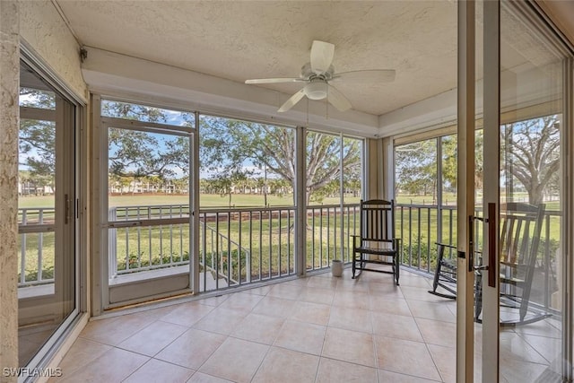 unfurnished sunroom featuring ceiling fan