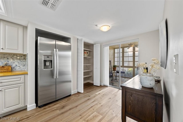 kitchen with white cabinetry, decorative backsplash, light wood-type flooring, and stainless steel fridge with ice dispenser