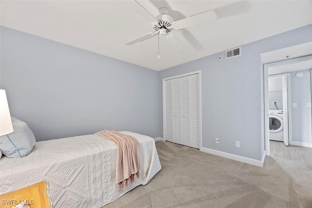 bedroom with washer / clothes dryer, light colored carpet, a closet, and ceiling fan