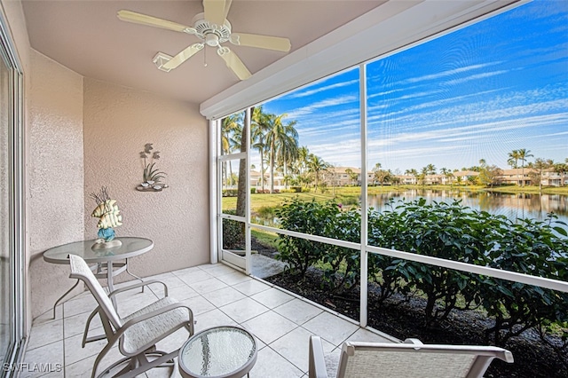 sunroom featuring a water view and ceiling fan