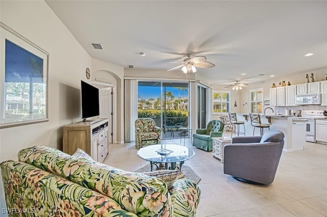 tiled living room featuring ceiling fan