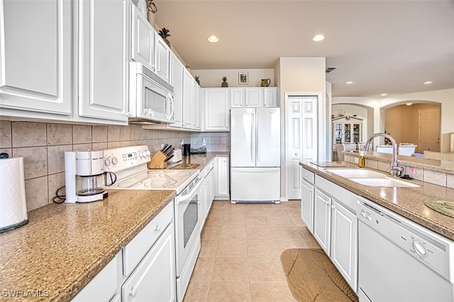 kitchen featuring sink, white appliances, light tile patterned floors, light stone countertops, and white cabinets