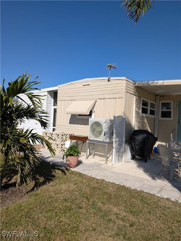 exterior space featuring ac unit, a patio area, and a lawn