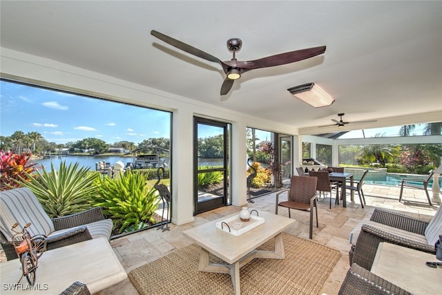 sunroom / solarium featuring a water view, a healthy amount of sunlight, and ceiling fan