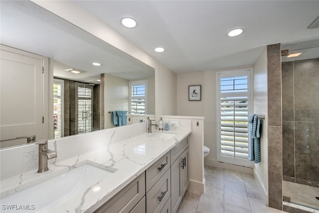 bathroom featuring vanity, tile patterned floors, toilet, and tiled shower