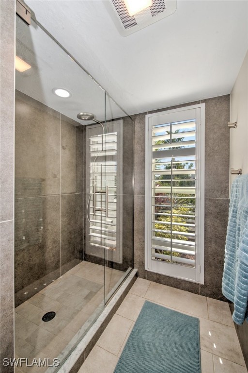 bathroom with an enclosed shower and tile patterned floors