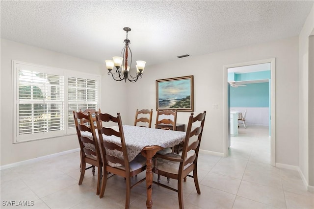 tiled dining space with an inviting chandelier and a textured ceiling