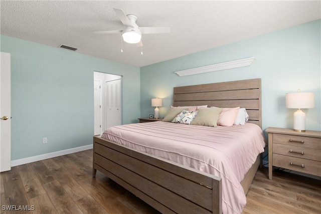 bedroom featuring ceiling fan, a closet, dark hardwood / wood-style floors, and a textured ceiling