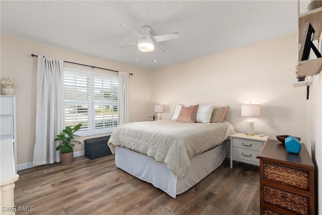 bedroom featuring ceiling fan, dark hardwood / wood-style flooring, and a textured ceiling